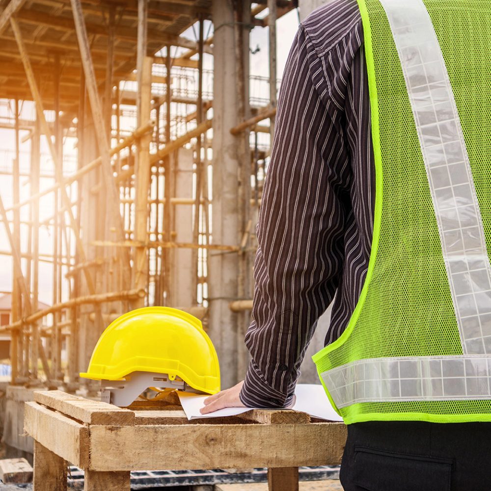 young business man professional engineer worker at the house building construction site with blueprint